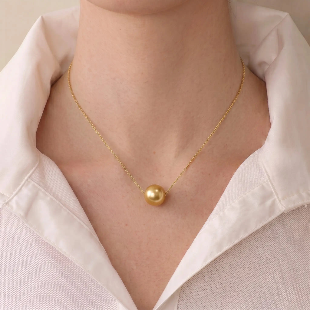 Front view of a model wearing the floating South Sea golden pearl necklace, displaying a clean, elegant silhouette on the neckline.