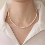 Woman wearing a solid gold freshwater pearl necklace and earrings set with a casual tee for effortless everyday polish.