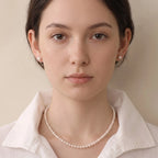 Woman wearing a solid gold freshwater pearl necklace and earrings set with a casual tee for effortless everyday polish.