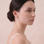 Woman wearing a solid gold freshwater pearl jewelry set outdoors, showcasing the natural pearl glow in everyday styling.