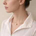 Side profile of a model wearing the floating AAA pearl and 18K gold bead necklace, showing its delicate drape.