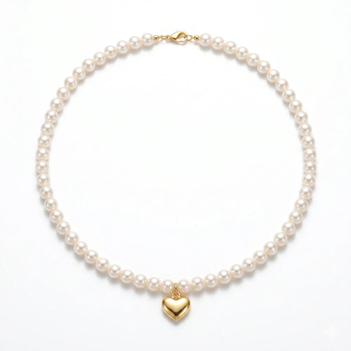Studio still life of a modernist pearl choker necklace featuring a polished solid 18K gold heart pendant, showcasing the flawless 5mm-5.5mm round pearls on a clean white background.