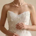 Front view of a model wearing the modern heart and pearl choker, showcasing the structural 18K gold heart pendant on a 5-5.5mm pearl strand.