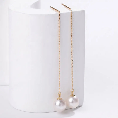 Macro photograph of AAA-quality Japanese Akoya seawater pearls on ultra-fine 18k gold threader chains, highlighting their legendary sharp mirror-like luster.