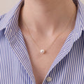 A close-up of a model wearing a 7mm Japanese Akoya pearl necklace, showing how the high-tensile 18K solid gold chain floats effortlessly along her collarbone.