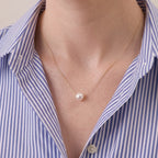 A close-up of a model wearing a 7mm Japanese Akoya pearl necklace, showing how the high-tensile 18K solid gold chain floats effortlessly along her collarbone.
