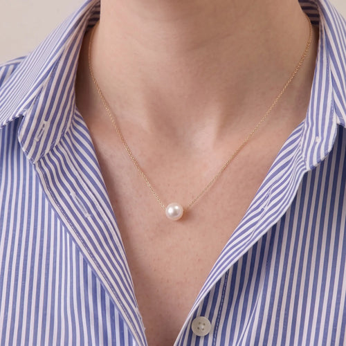 A close-up of a model wearing a 7mm Japanese Akoya pearl necklace, showing how the high-tensile 18K solid gold chain floats effortlessly along her collarbone.