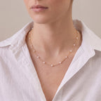 Woman wearing a 3–3.5mm Baby Akoya pearl necklace with an 18K solid gold chain for a refined luxury look.