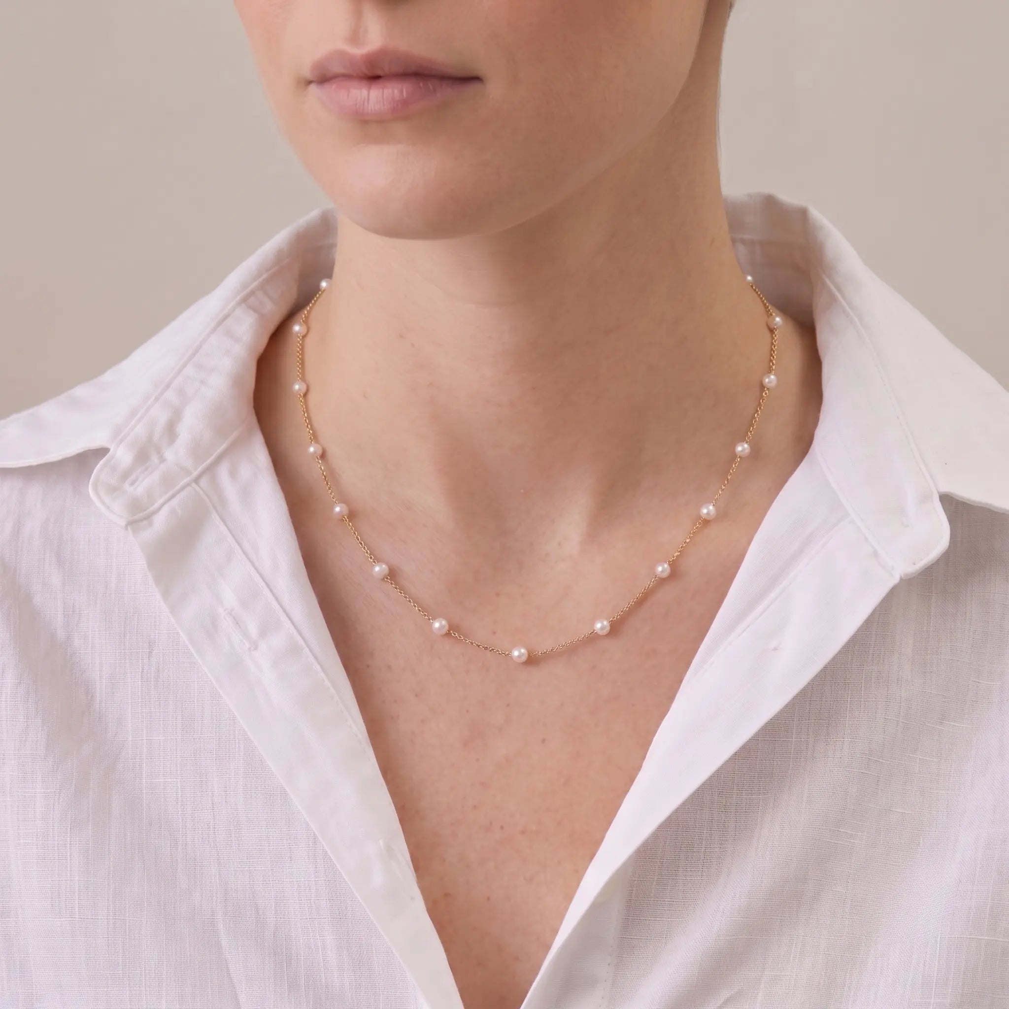 Woman wearing a 3–3.5mm Baby Akoya pearl necklace with an 18K solid gold chain for a refined luxury look.