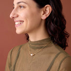 A delicate 18k solid yellow gold floating-style solitaire pearl necklace resting on the collarbone, emphasizing a tarnish-free and hypoallergenic finish for lifetime wear.