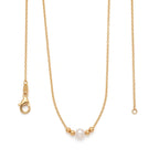 Close-up of an 18k solid gold solitaire pearl necklace featuring a hand-selected 7-7.5mm genuine pearl flanked by two real gold beads.