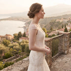 Side profile of a bride wearing a cascading baroque pearl necklace, highlighting the elegant Y-chain silhouette and neckline.