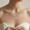 Close-up of a bridal model in a strapless sweetheart wedding dress, showcasing the rich fluid texture of a double-layer 18K solid gold floating pearl choker along her collarbon
