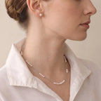 Side profile of a woman wearing a delicate pearl necklace, highlighting the lightweight strand and elegant neckline.