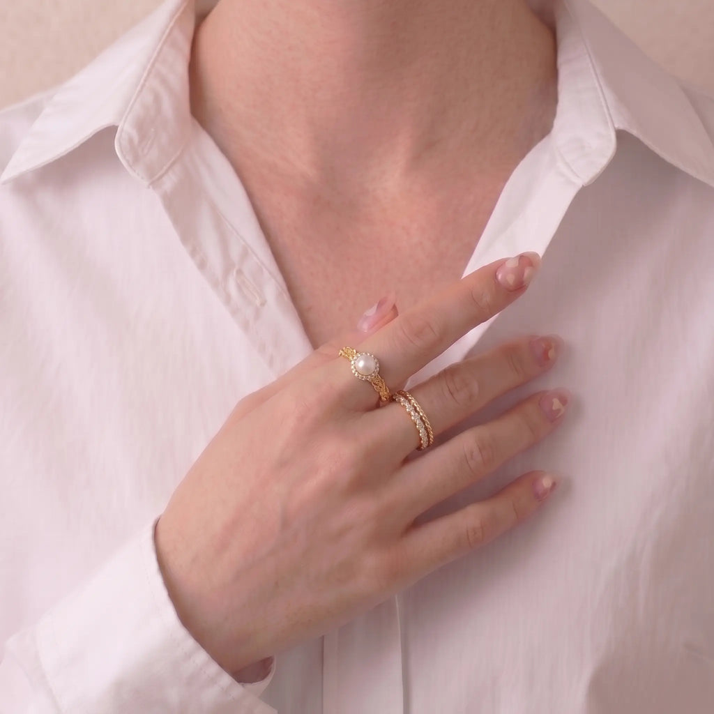 Side profile of a model's finger wearing the Akoya pearl moon ring, detailing the artisanal wavy brushed-gold texture and adjustable open-shank design.