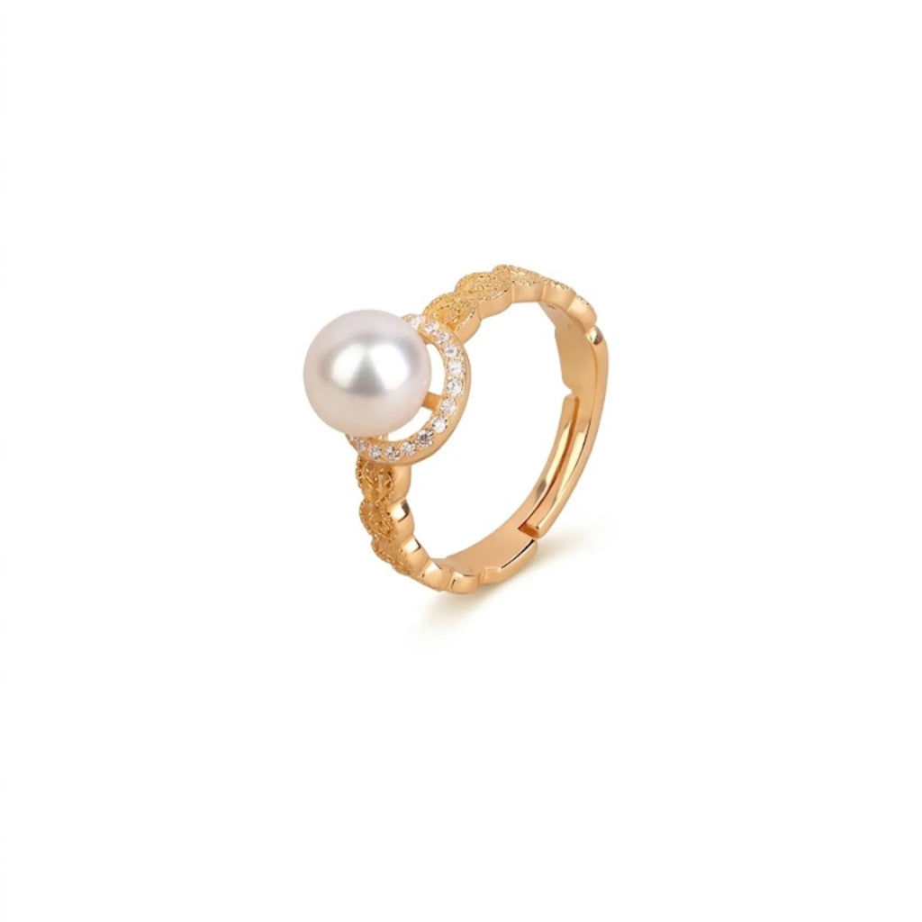 Product packshot of the Golden Lunar Muse ring featuring a 7-7.5mm Akoya pearl, pave-set cubic zirconia crescent moon, and wavy brushed-gold adjustable band, isolated on white.