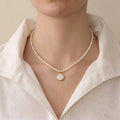 Woman wearing a freshwater rice pearl shell pendant necklace for a modern coastal luxury jewelry look.