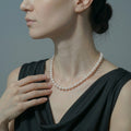A classic round white freshwater pearl necklace with a polished sterling silver clasp