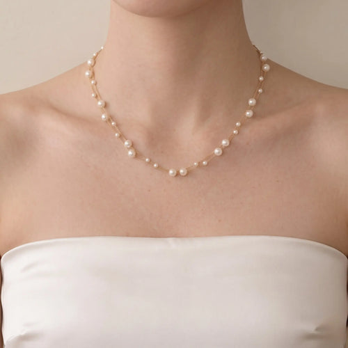 An elegant bride wearing a two-layer real freshwater baby pearl choker for a modern romantic wedding fine jewelry statement.