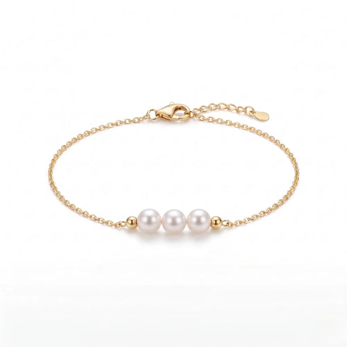 Onepearlife solid 18K gold three-pearl seed bracelet flat lay on a stark white studio background, showcasing the precision engineering of the secure clasp and the seamless alignment of the pearl trio.