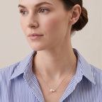 Side view of a model in a white linen shirt showcasing the sharp mirror-like luster of the 5.0mm and 7.5mm Japanese Akoya pearls at the collarbone.