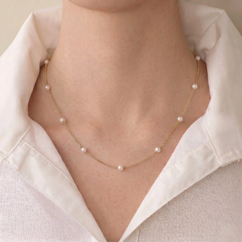 Minimalist profile view of a woman wearing a relaxed white silk blouse; the subtle, mirror-like luster of the Onepearlife fine pearl choker adds an intellectual, quiet luxury edge to her look.