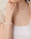 Model wearing the dainty 6-6.5mm freshwater pearl bracelet, a delicate minimalist strand for a subtle glow.