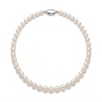 Wedding flatlay featuring a meticulously handcrafted white pearl strand alongside bridal accessories and invitations.