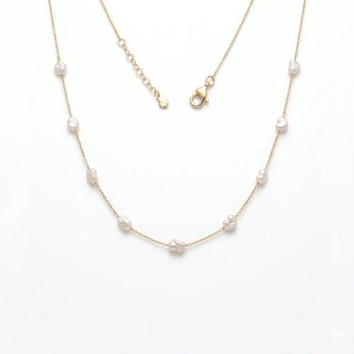 Studio still life of a pair of minimalist 18k solid gold baby baroque pearl choker strands, focusing on the 4mm-5mm delicate irregular pearls.