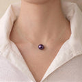 Front view of a professional woman wearing an unbuttoned white shirt, styled with an invisible floating metallic purple Edison pearl necklace for a bold everyday look.