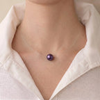 Front view of a professional woman wearing an unbuttoned white shirt, styled with an invisible floating metallic purple Edison pearl necklace for a bold everyday look.