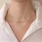 Woman wearing a 2–2.5mm freshwater pearl necklace resting along the collarbone for a subtle luxury look.